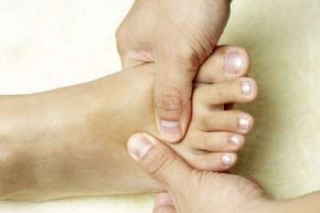 A masseuse massaging the foot of a woman