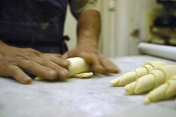 Baker making croissants