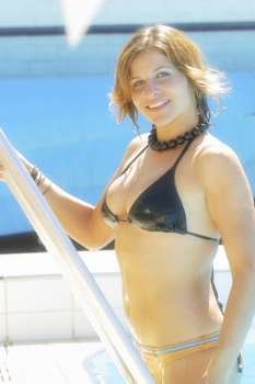 A sexy woman wearing a black bikini relaxes at the local pool.