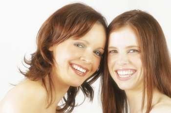 Two young Australian women in studio smiling at eachother.