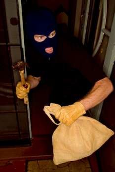 A stock Photograph of aaburglar robbing a house wearing a balaclava.a
