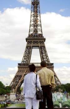 Tourist couple enjoying the view of Eiffel tower in Paris, France.
