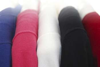 Colorful women´s sweaters on a rack on padded hangers