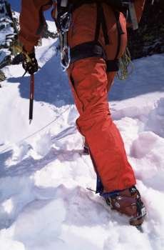 Mountain climber going up snowy mountain (selective focus)