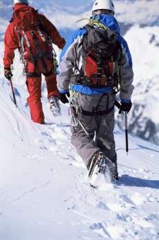 Two mountain climbers walking in snow (selective focus)