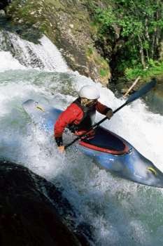 Kayaker in rapids going over waterfall (blur)