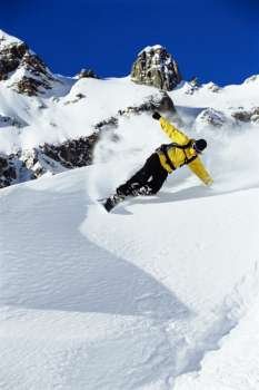 Snowboarder coming down snowy hill