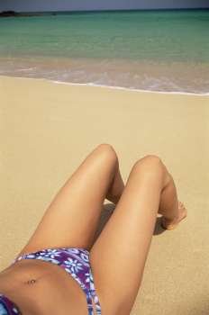 Woman´s legs outdoors lying on beach