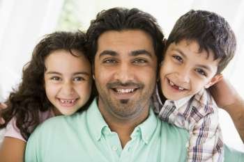 Father and two young children in living room smiling (high key)