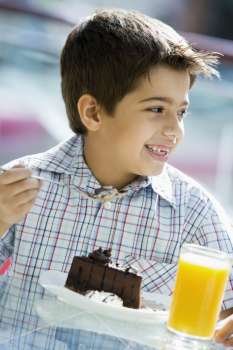 Young boy at restaurant eating dessert and smiling (selective focus)
