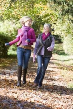 Two women running outdoors in park and smiling