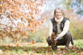 Woman outdoors holding leaves and smiling (selective focus)