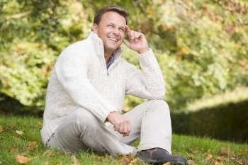 Man sitting outdoors smiling (selective focus)
