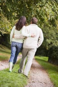 Couple walking outdoors on path in park (selective focus)