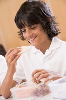 Student in cafeteria eating lunch (selective focus)