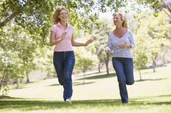 Two women running in park and smiling