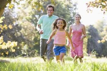 Family running outdoors smiling
