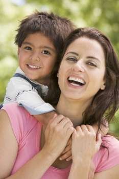 Woman and young boy embracing outdoors smiling