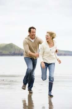 Couple running on beach smiling