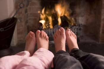Couple´s feet warming at a fireplace