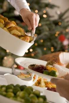 Serving Roast Potatoes at Christmas Lunch