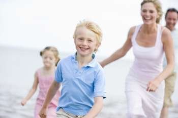 Family running on beach smiling