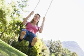 Woman on tree swing smiling