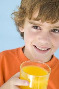 Young boy with glass of orange juice smiling