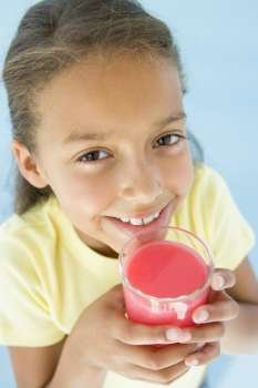 Young girl with glass of juice smiling