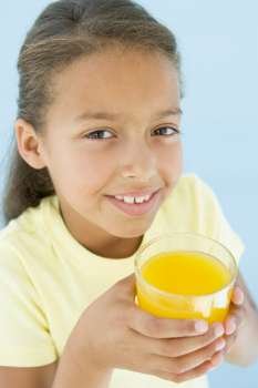 Young girl with glass of orange juice smiling
