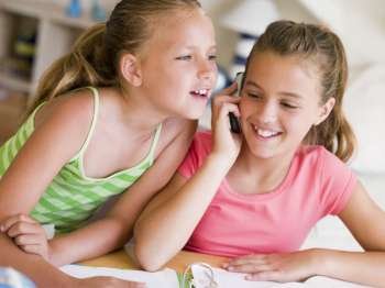 Young Girls Distracted From Their Homework, Talking On A Cellphone