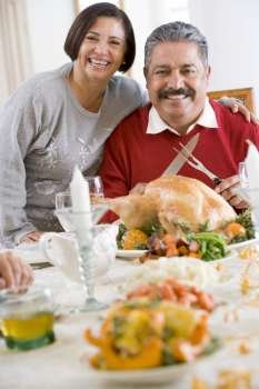 Woman With Her Arm Around Her Husband,Who Is Getting Ready To Carve A Turkey