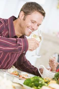 Man Drinking Wine At Christmas Dinner
