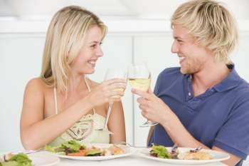 Young Couple Enjoying meal,mealtime With A Glass Of Wine