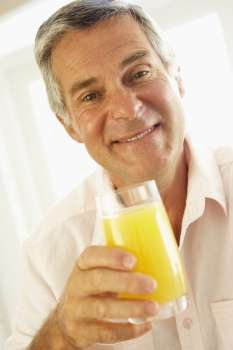 Middle Aged Man Drinking A Glass Of Orange Juice