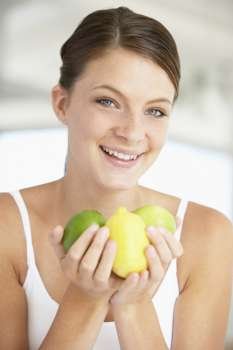 Young Woman Holding Fresh Fruit And Smiling At The Camera