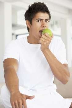 Young Man Eating A Green Apple