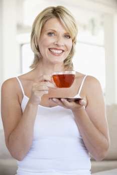 Mid Adult Woman Holding Tea Cup And Smiling At Camera