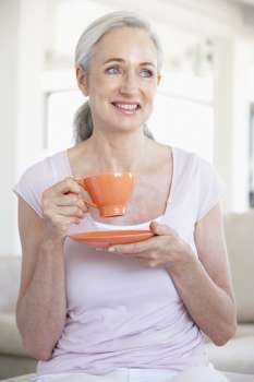 Senior Woman Holding Tea And Smiling At The Camera