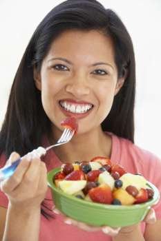 Mid Adult Woman Eating Fresh Fruit Salad