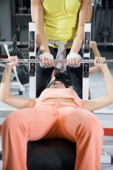 health club: girl in a gym doing weight lifting