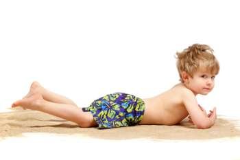 Boy laying on a sand pile on an isolated background 