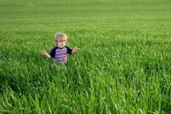 Young boy walks through a field of grass 