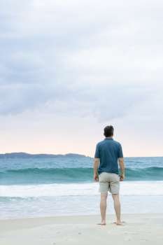 Man standing on the beach contemplating the sea 