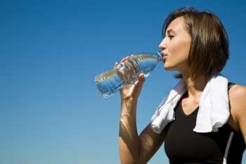 A beautiful sporty caucasian girl drinking water after exercise