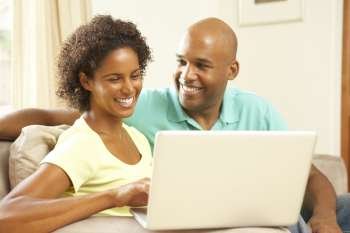Couple Using Laptop At Home