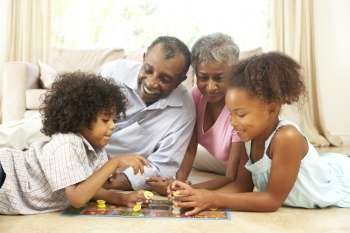 Grandparents Playing Board Game At Home With Grandchildren