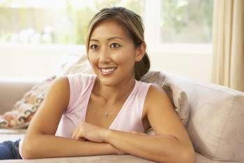 Young Woman Relaxing On Sofa At Home