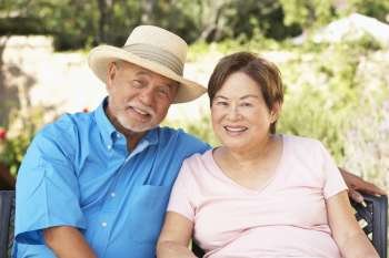 Senior Couple Relaxing In Garden Together