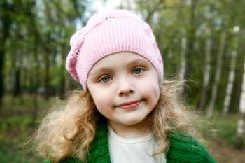 Portrait of the beautiful little girl with long hair in forest 